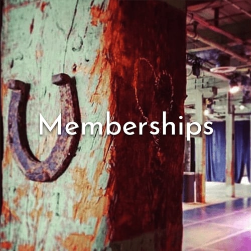 Shot of a beam in the space with a horse shoe nailed onto it. Text overtop says "Memberships".