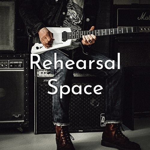 Shot of a guitarist playing the guitar. Text says "Rehearsal Space".
